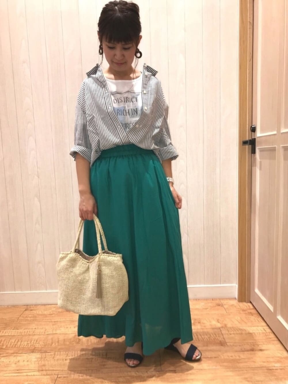 ブラック系のシャツ/ブラウス、ブルー系のサンダル、ベージュ系のトートバッグを着用したレディースの春コーディネートの1枚目の写真