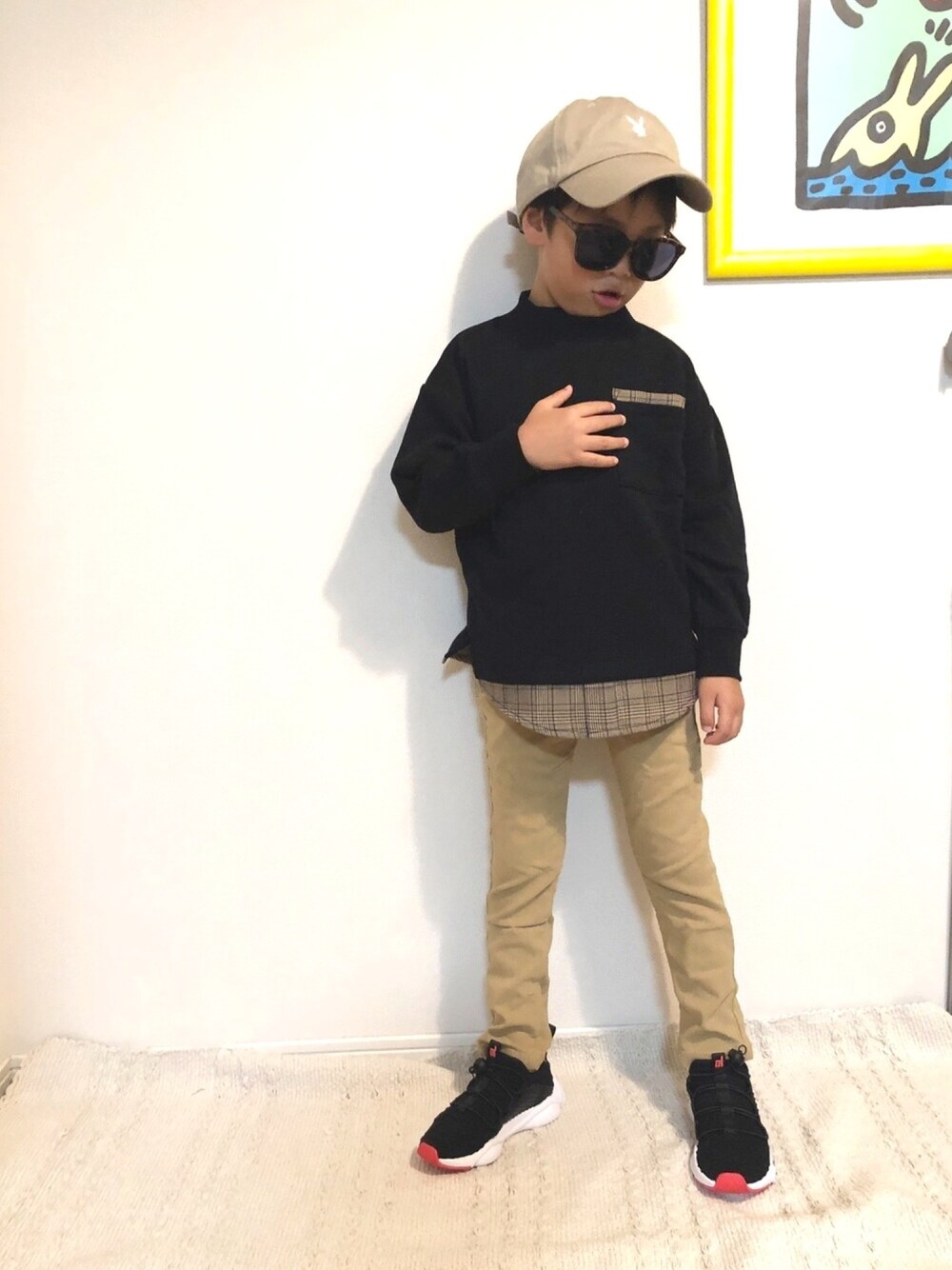 ブラック系のスウェット、ベージュ系のチノパンツを着用したキッズの秋コーディネートの1枚目の写真
