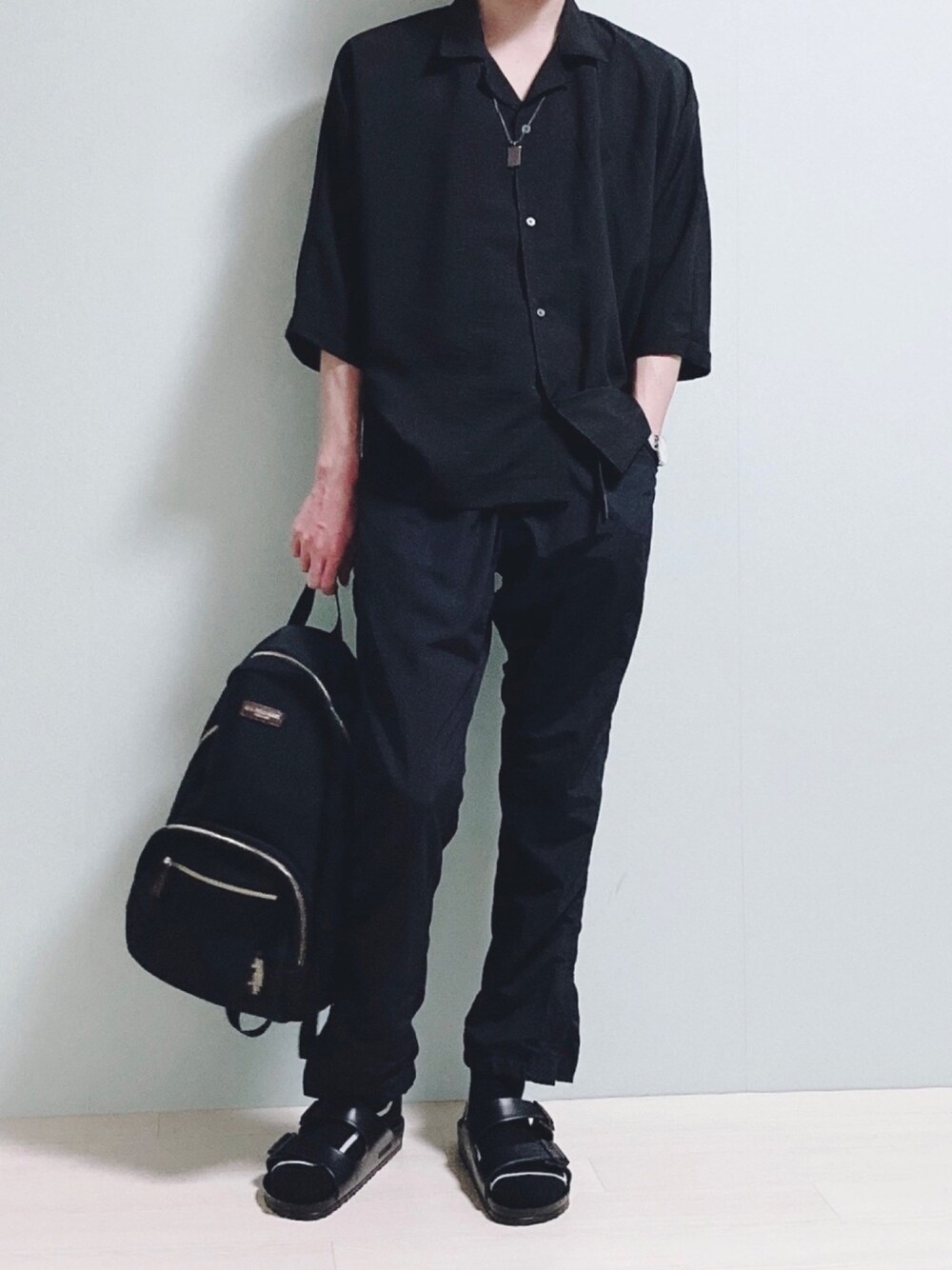 ブラック系のシャツ/ブラウス、ブラック系のチノパンツ、ブラック系のバックパック/リュックを着用したメンズの夏コーディネートの1枚目の写真
