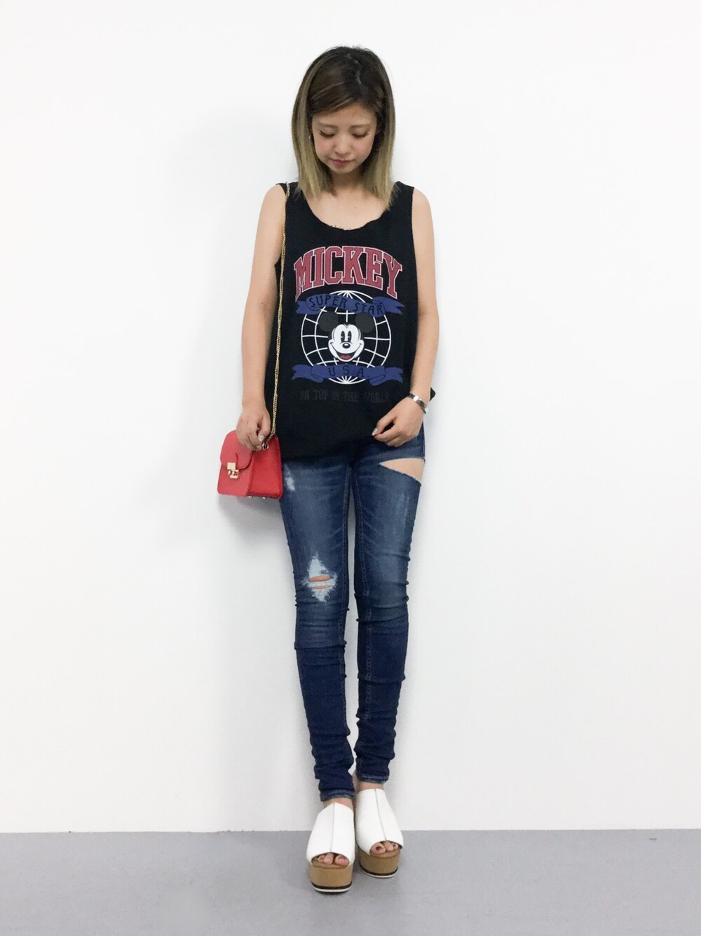 ブラック系のタンクトップ、ブルー系のデニムパンツを着用したレディースの夏コーディネートの1枚目の写真