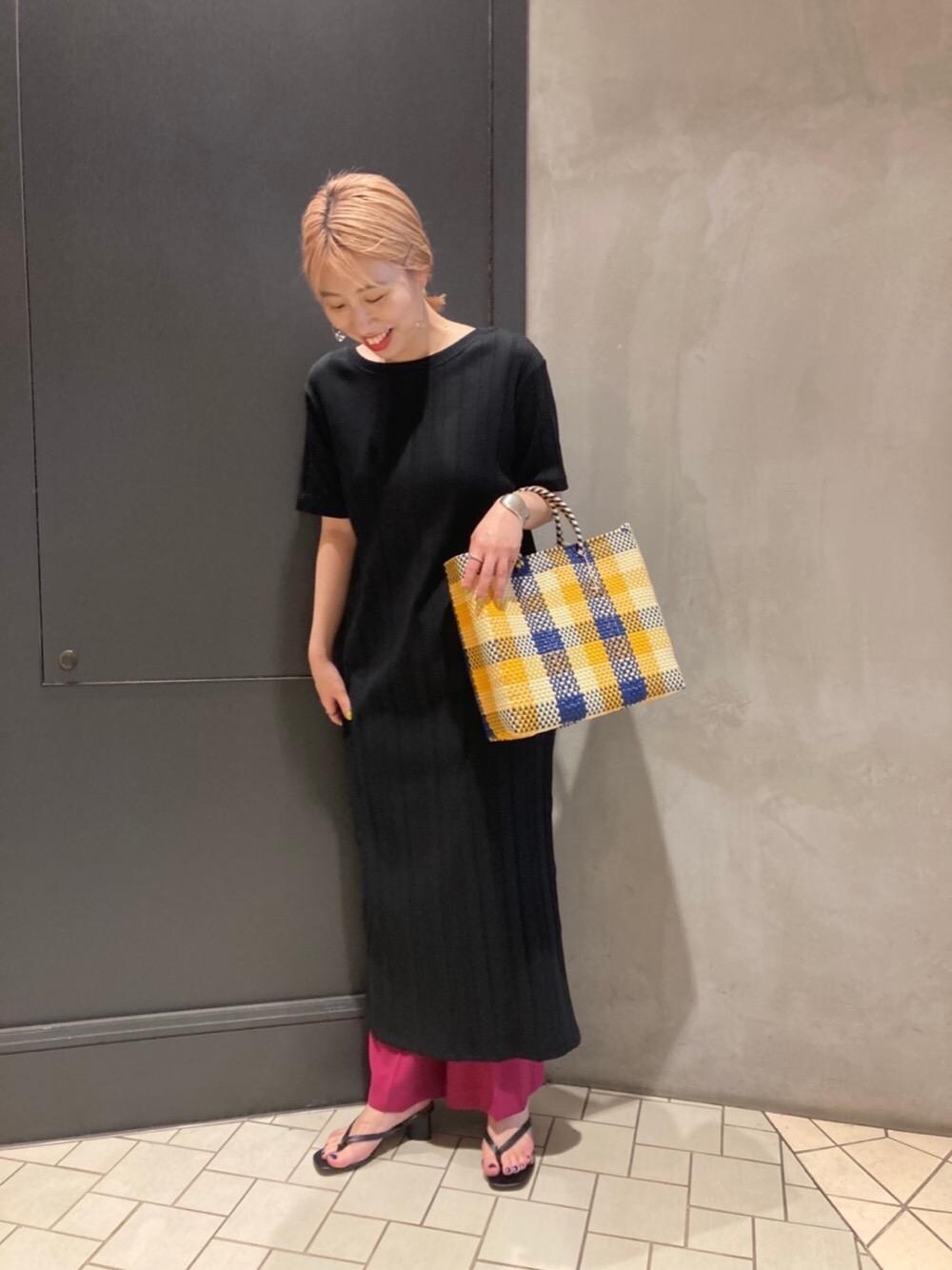 イエロー系のかごバッグ、ブラック系のサンダル、ブラック系のワンピースを着用したレディースの春コーディネートの1枚目の写真