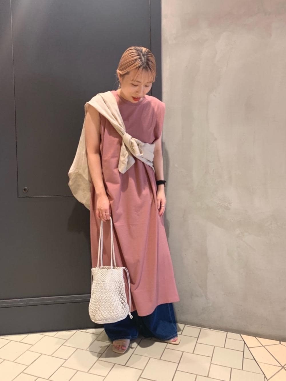 ベージュ系のサンダル、ブルー系のデニムパンツ、ホワイト系のショルダーバッグを着用したレディースの夏コーディネートの1枚目の写真