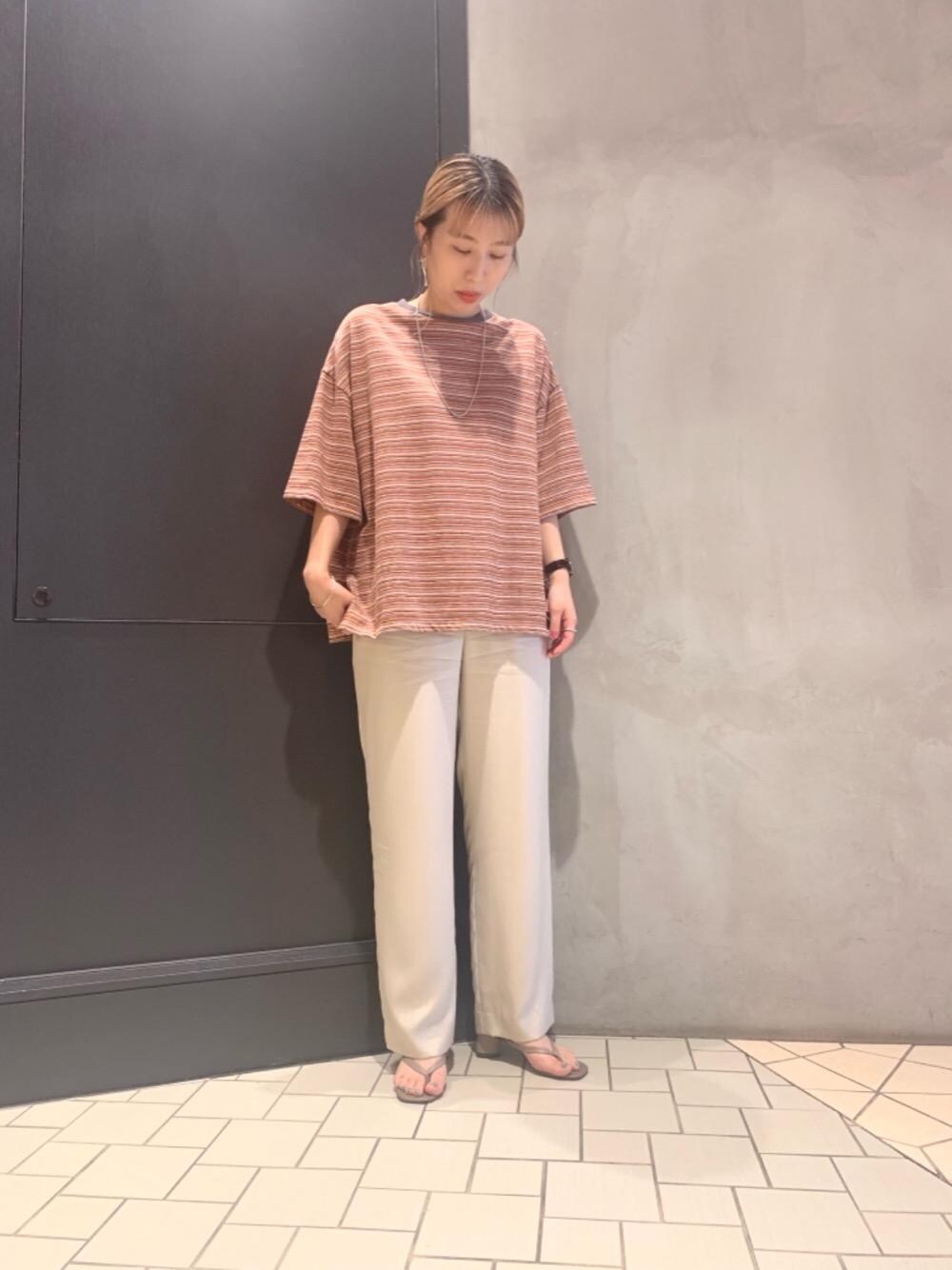 ブラウン系のサンダル、ベージュ系のその他パンツ、オレンジ系のTシャツ/カットソーを着用したレディースの夏コーディネートの1枚目の写真