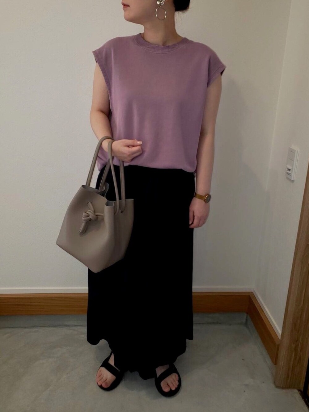 ブラック系のパンツ、グレー系のハンドバッグ、ブラック系のサンダルを着用したレディースの夏コーディネートの1枚目の写真