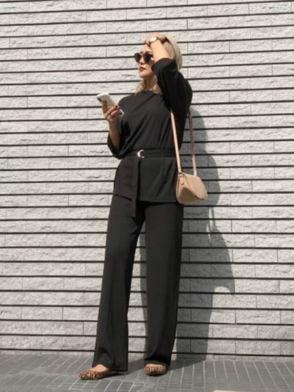 ベージュ系のショルダーバッグ、ブラック系のTシャツ/カットソー、ブラック系のその他パンツを着用したレディースの秋コーディネートの1枚目の写真