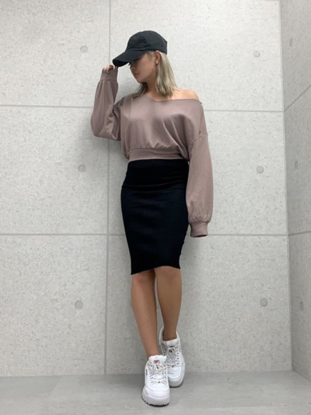 ブラウン系のTシャツ/カットソー、ブラック系のスカート、ブラック系のキャップを着用したレディースの秋コーディネートの1枚目の写真
