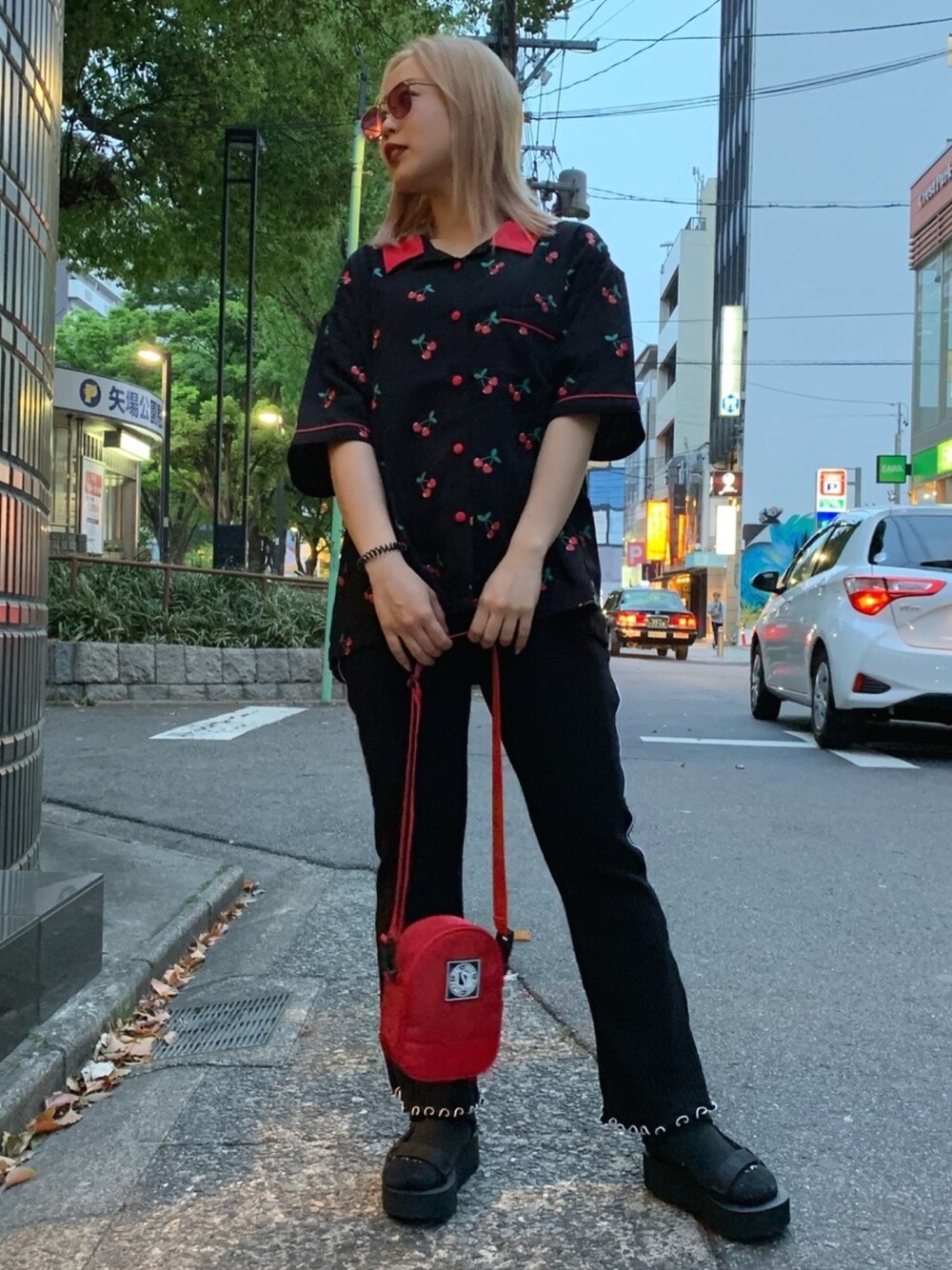 ブラック系のその他パンツ、ブラック系のシャツ/ブラウス、レッド系のショルダーバッグを着用したレディースの春コーディネートの1枚目の写真