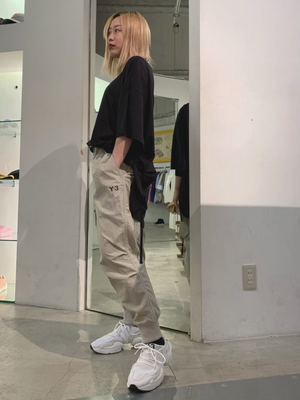 ブラック系のTシャツ/カットソー、ベージュ系のパンツ、ホワイト系のスニーカーを着用したレディースの春コーディネートの1枚目の写真