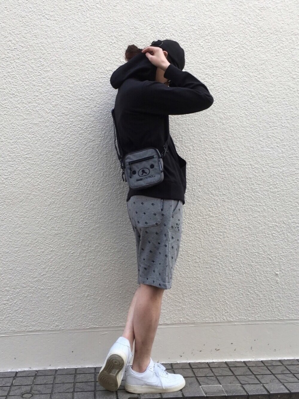 ブラック系のパーカー、グレー系のショルダーバッグ、グレー系のスウェットパンツを着用したメンズの冬コーディネートの1枚目の写真