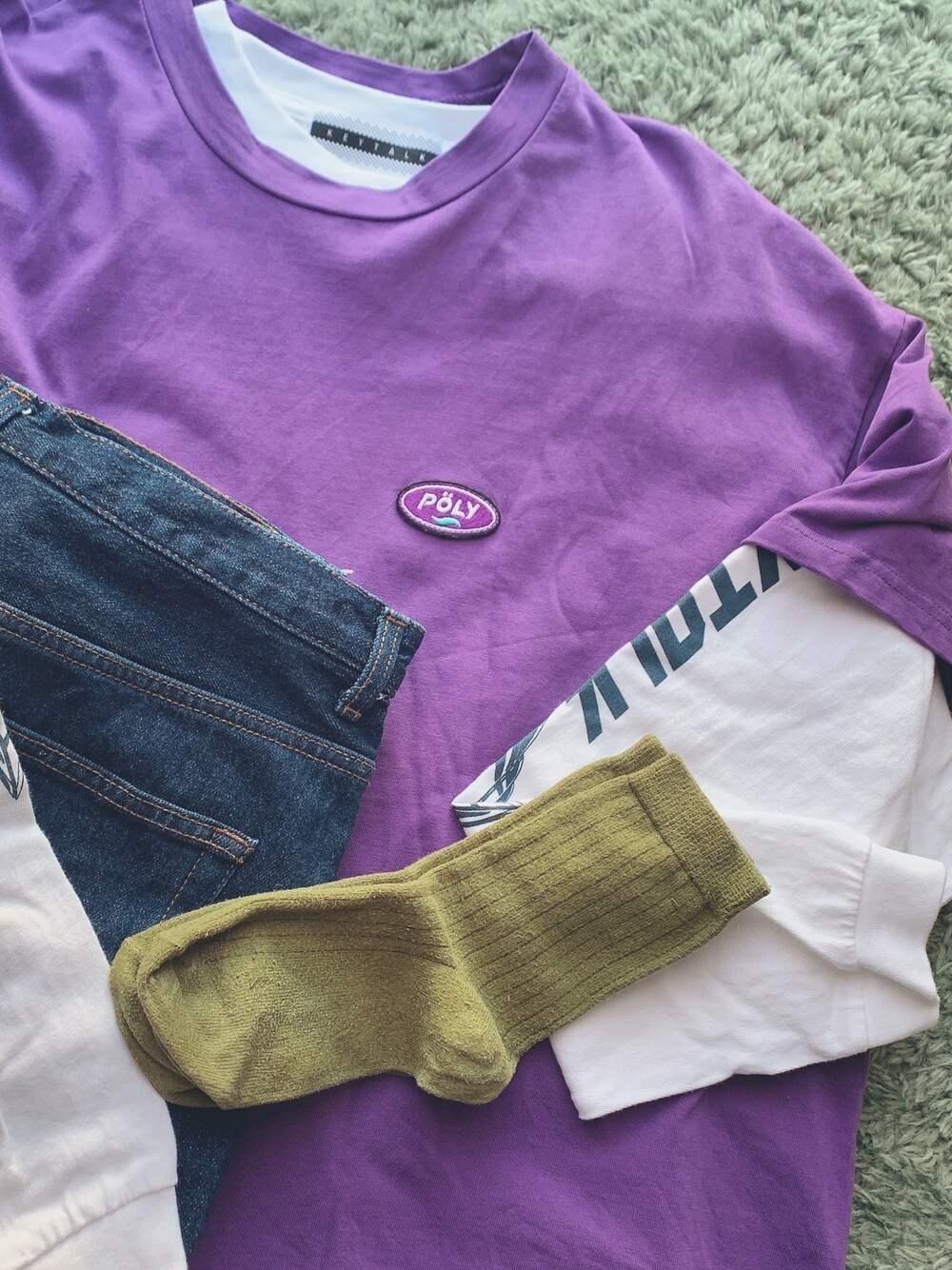 パープル系のTシャツ/カットソー、ホワイト系のTシャツ/カットソー、ブラック系のデニムパンツを着用したレディースの秋コーディネートの1枚目の写真