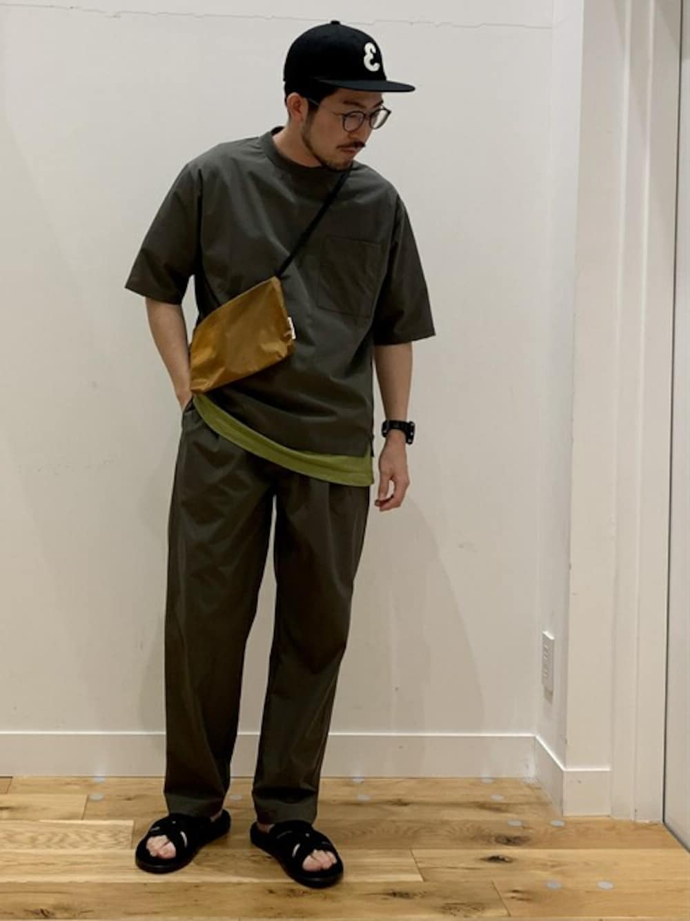 グリーン系のTシャツ/カットソー、グリーン系のその他パンツ、イエロー系のショルダーバッグを着用したメンズの春コーディネートの1枚目の写真