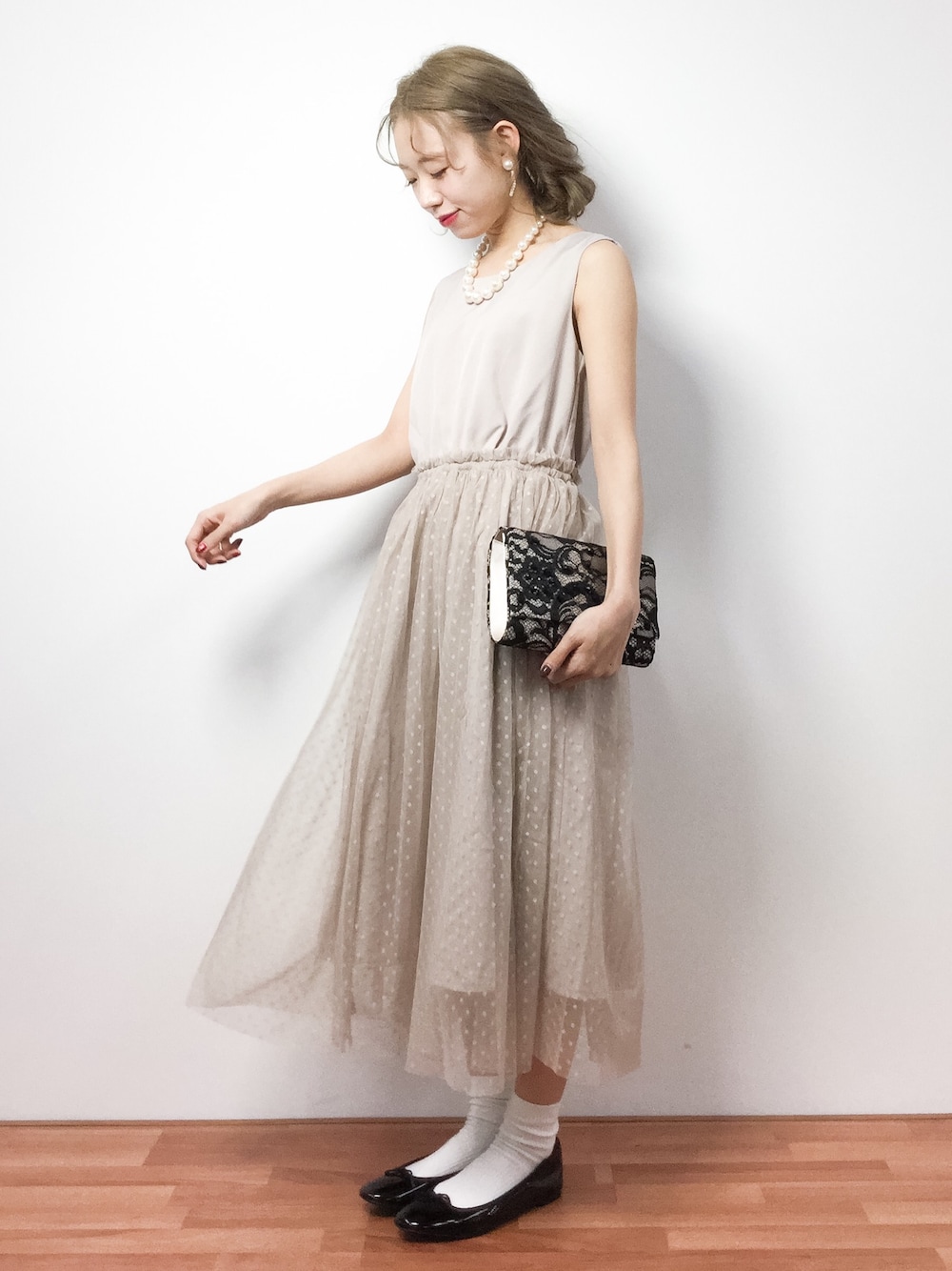 ベージュ系のワンピース、ブラック系のクラッチバッグ、ブラック系のバレエシューズを着用したレディースの冬コーディネートの1枚目の写真