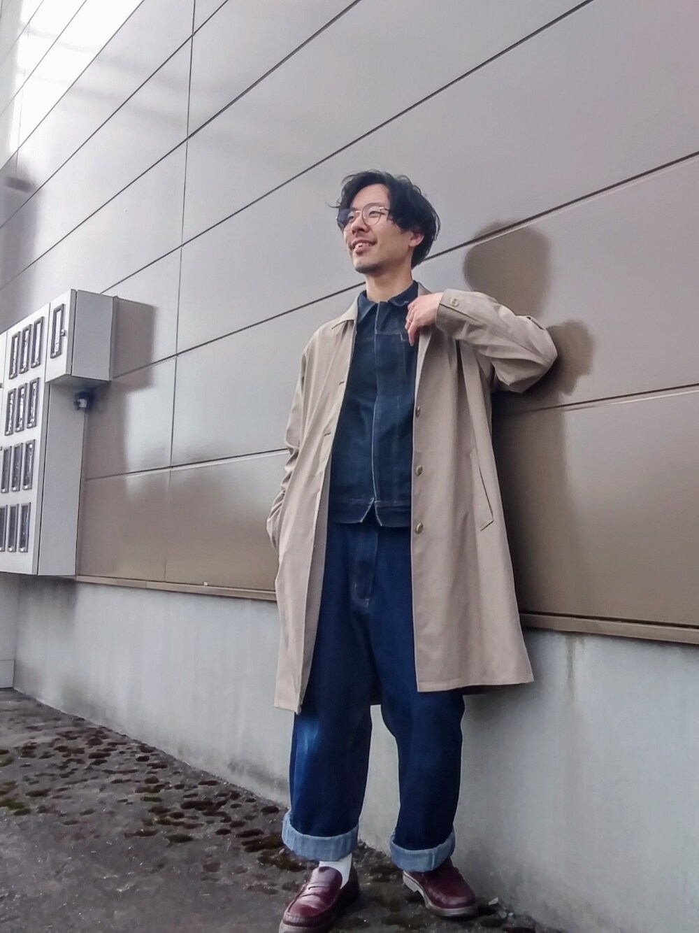 ベージュ系のステンカラーコート、ブルー系のデニムパンツ、ブルー系のデニムジャケットを着用したメンズの春コーディネートの1枚目の写真