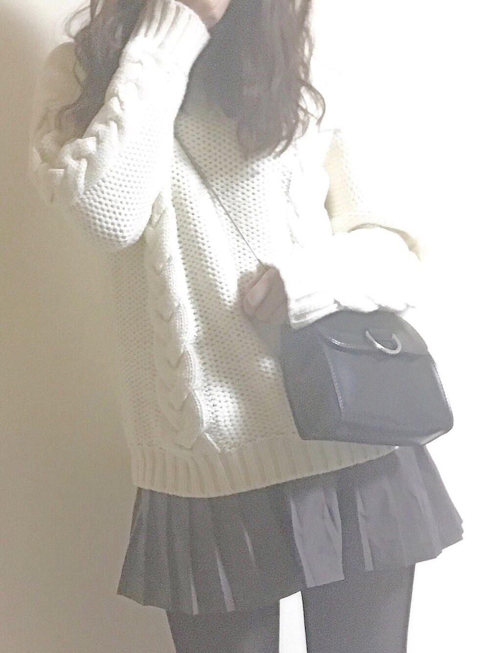 ホワイト系のニット/セーター、グレー系のパンツ、ブラック系のショルダーバッグを着用したレディースの冬コーディネートの1枚目の写真