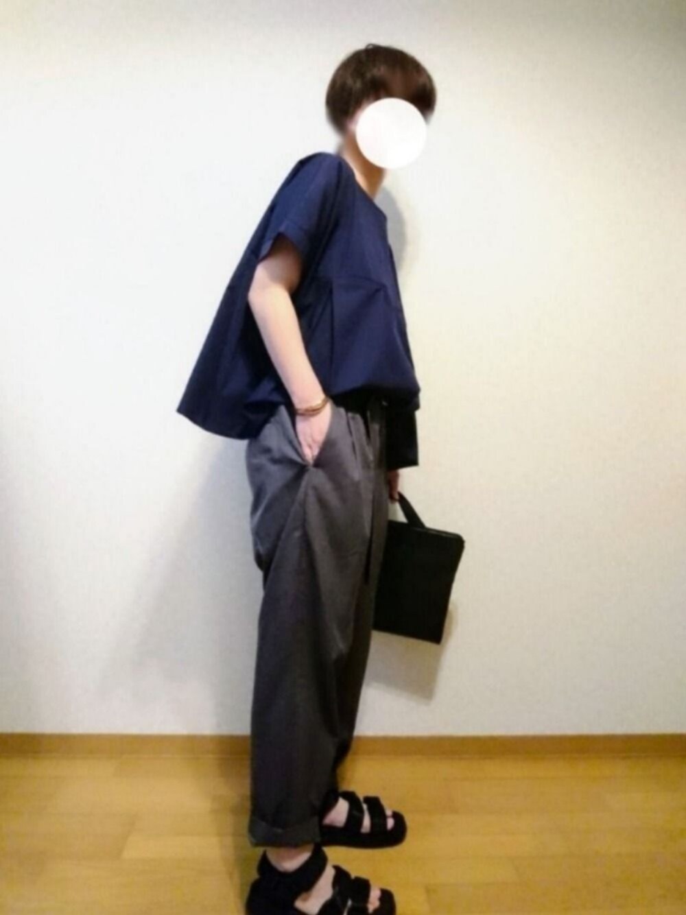 ブラック系のサンダル、グレー系のその他パンツ、ブラック系のビジネスバッグを着用したレディースの夏コーディネートの1枚目の写真