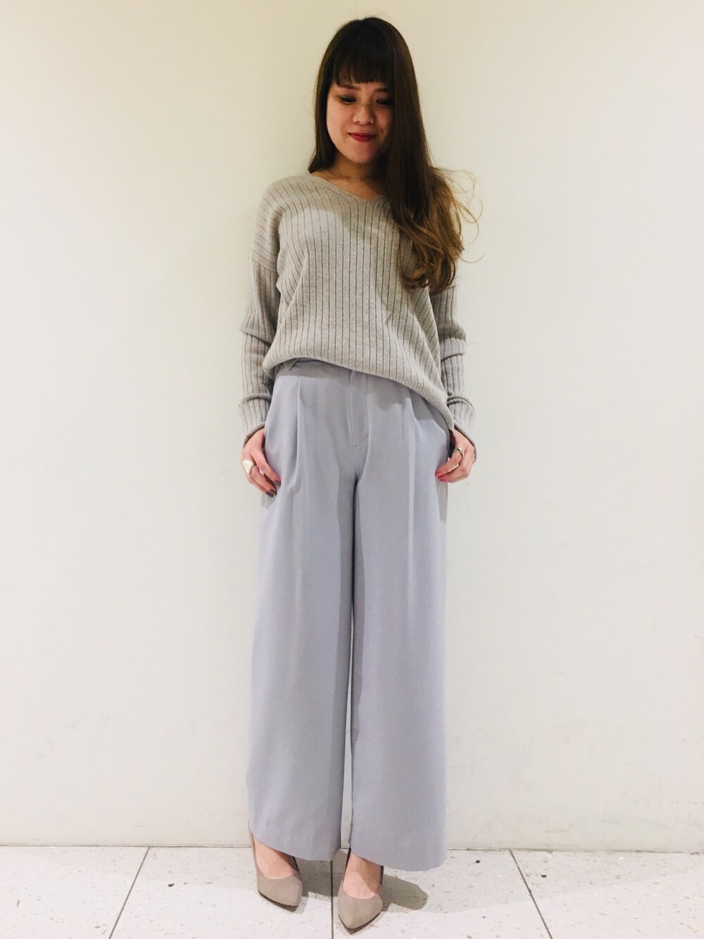 グレー系のニット/セーター、ブルー系のその他パンツ、ベージュ系のパンプスを着用したレディースの秋コーディネートの1枚目の写真