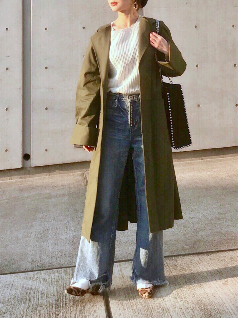 ホワイト系のニット/セーター、ブラック系のトートバッグ、グリーン系のトレンチコートを着用したレディースの春コーディネートの1枚目の写真