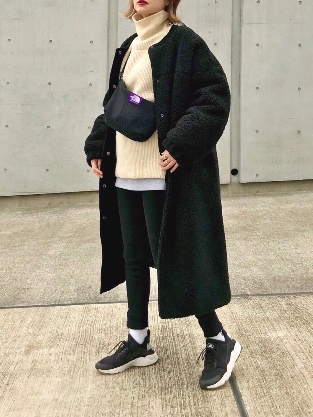 ブラック系のその他アウター、ホワイト系のニット/セーター、ブラック系のバッグを着用したレディースの冬コーディネートの1枚目の写真