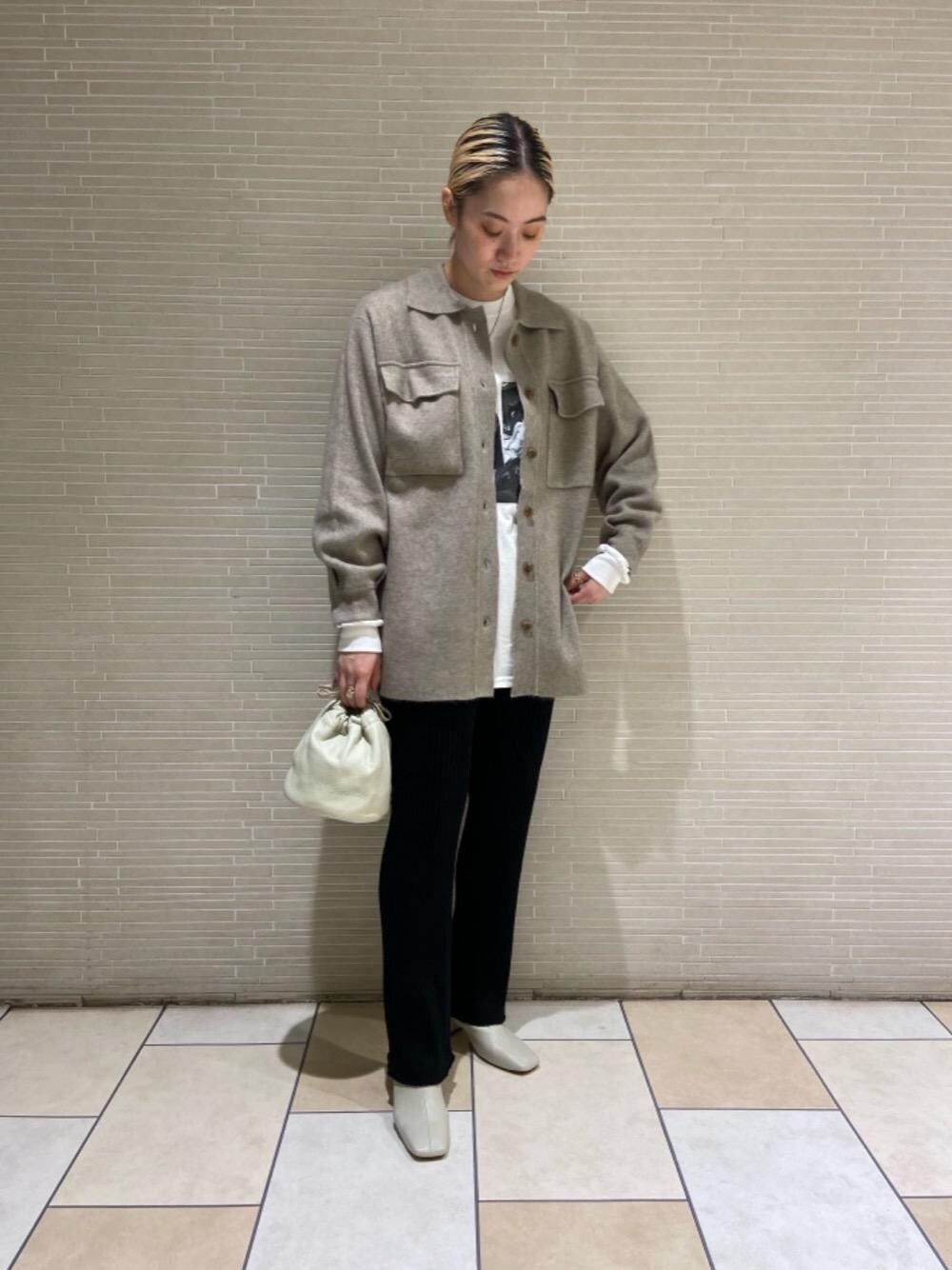 ベージュ系のショルダーバッグ、ホワイト系のブーツ、ホワイト系のTシャツ/カットソーを着用したレディースの秋コーディネートの1枚目の写真