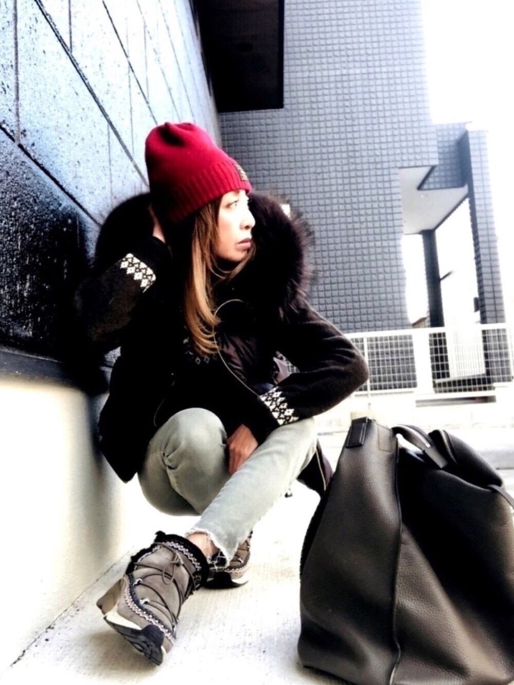 グレー系のダウンベスト、グレー系のスニーカー、グレー系のバックパック/リュックを着用したレディースの秋コーディネートの1枚目の写真