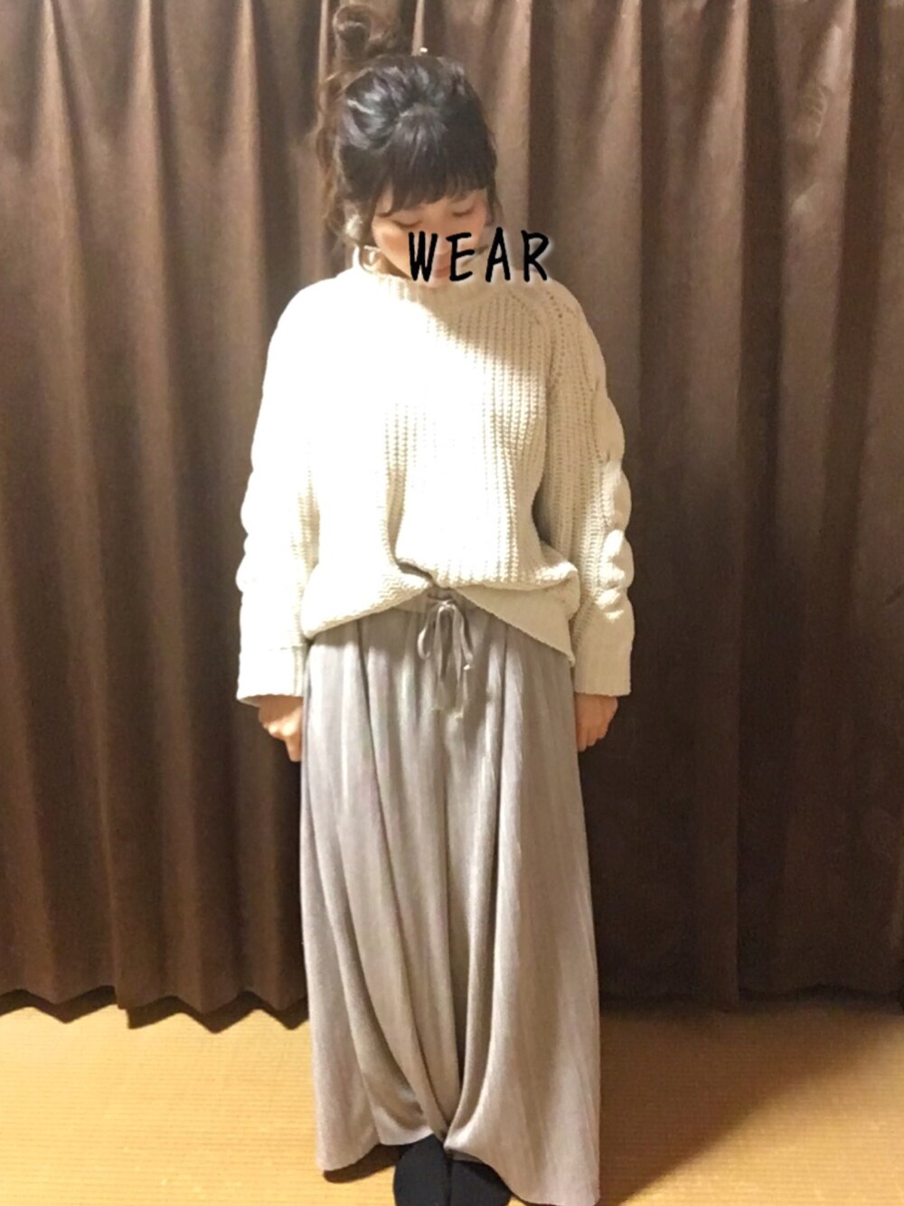 ホワイト系のニット/セーター、グレー系のパンツを着用したレディースの冬コーディネートの1枚目の写真