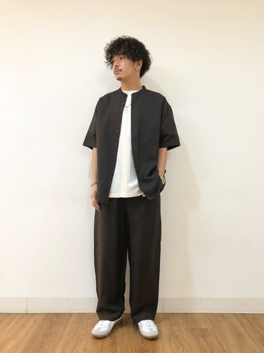 ホワイト系のトップス、ベージュ系のシャツ/ブラウス、ホワイト系のスニーカーを着用したメンズの春コーディネートの1枚目の写真