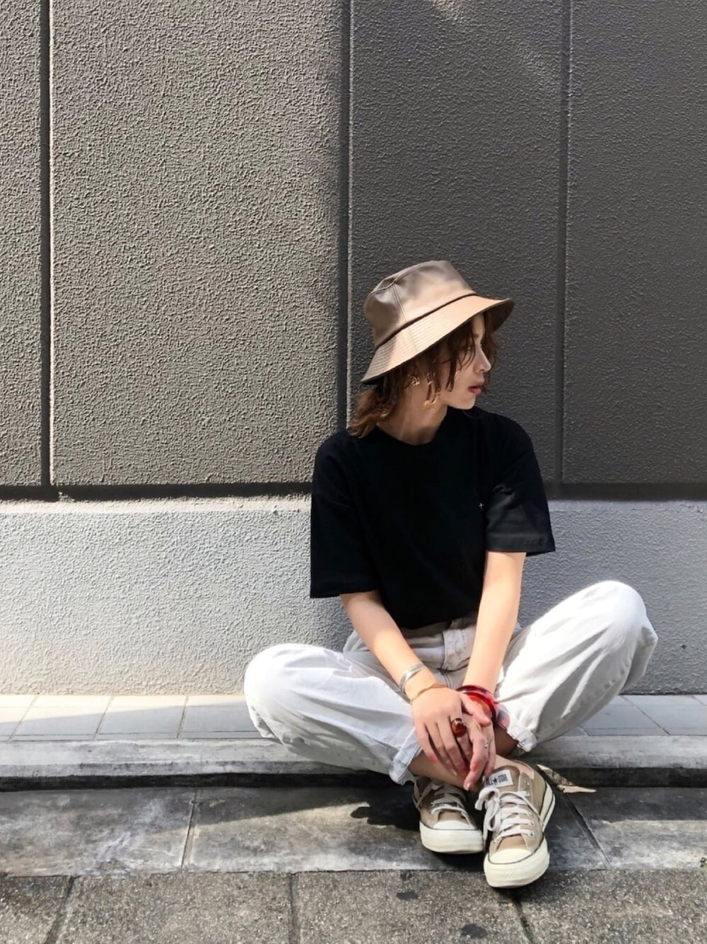 ブラック系のTシャツ/カットソー、ブルー系のデニムパンツ、ブラウン系のスニーカーを着用したレディースの秋コーディネートの1枚目の写真