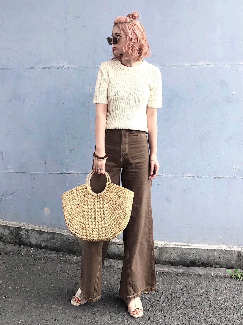 ホワイト系のニット/セーター、ブラウン系のデニムパンツ、ベージュ系のサンダルを着用したレディースの春コーディネートの1枚目の写真