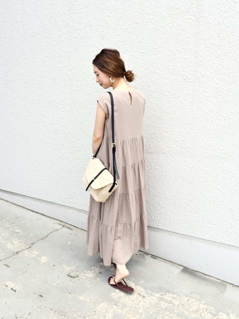 ベージュ系のワンピース、ベージュ系のショルダーバッグ、ホワイト系のピアス（両耳用）を着用したレディースの夏コーディネートの1枚目の写真
