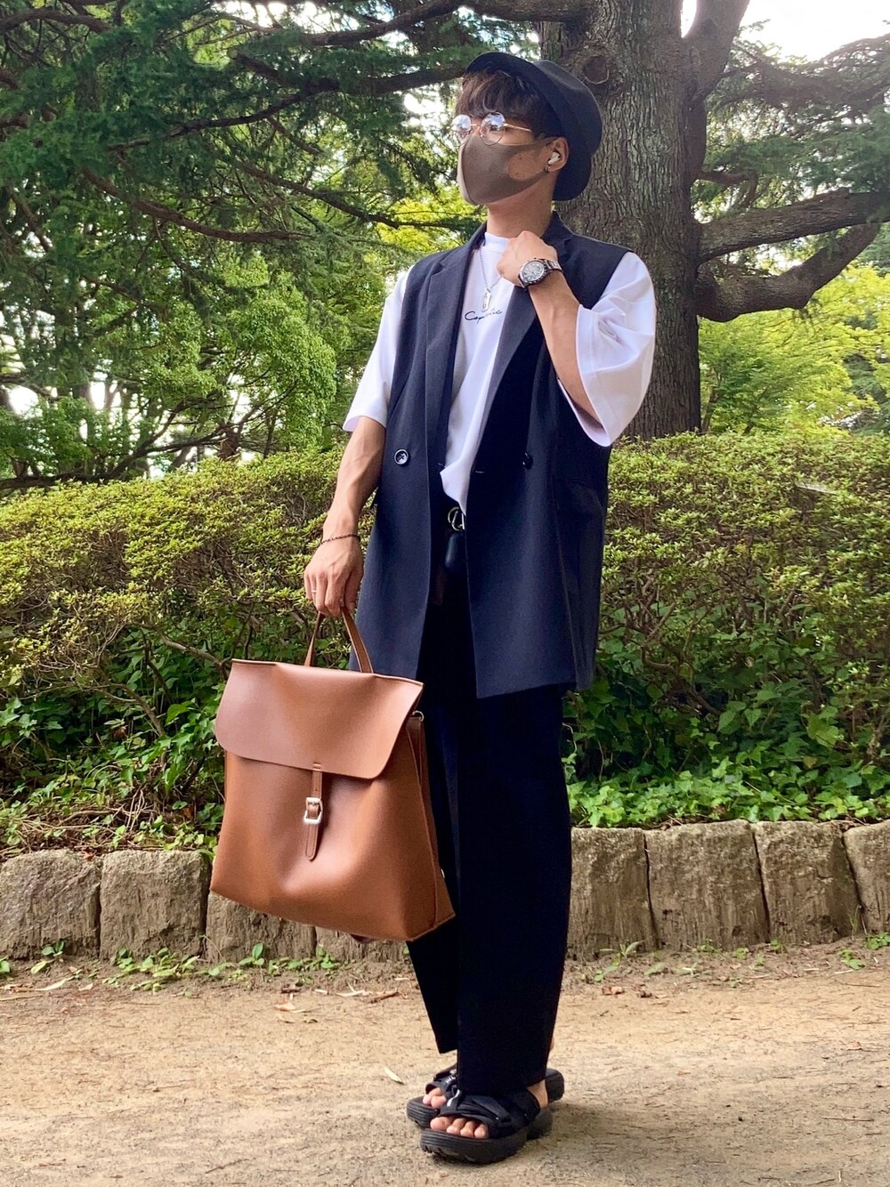 ホワイト系のTシャツ/カットソー、ブラック系のベスト、ブラウン系のバックパック/リュックを着用したメンズの夏コーディネートの1枚目の写真