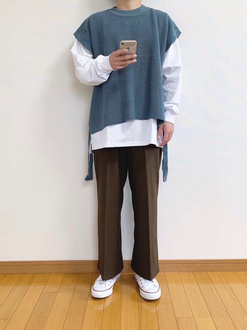 ブルー系のベスト、ホワイト系のTシャツ/カットソー、ブラウン系のスラックスを着用したメンズの秋コーディネートの1枚目の写真