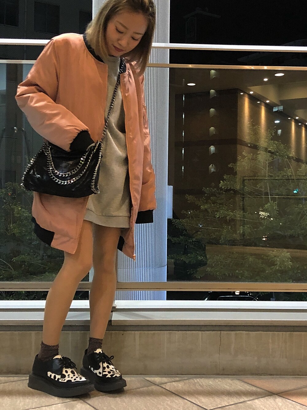 ピンク系のジャケット/アウター、ブラック系のバッグ、グレー系のワンピースを着用したレディースの冬コーディネートの1枚目の写真