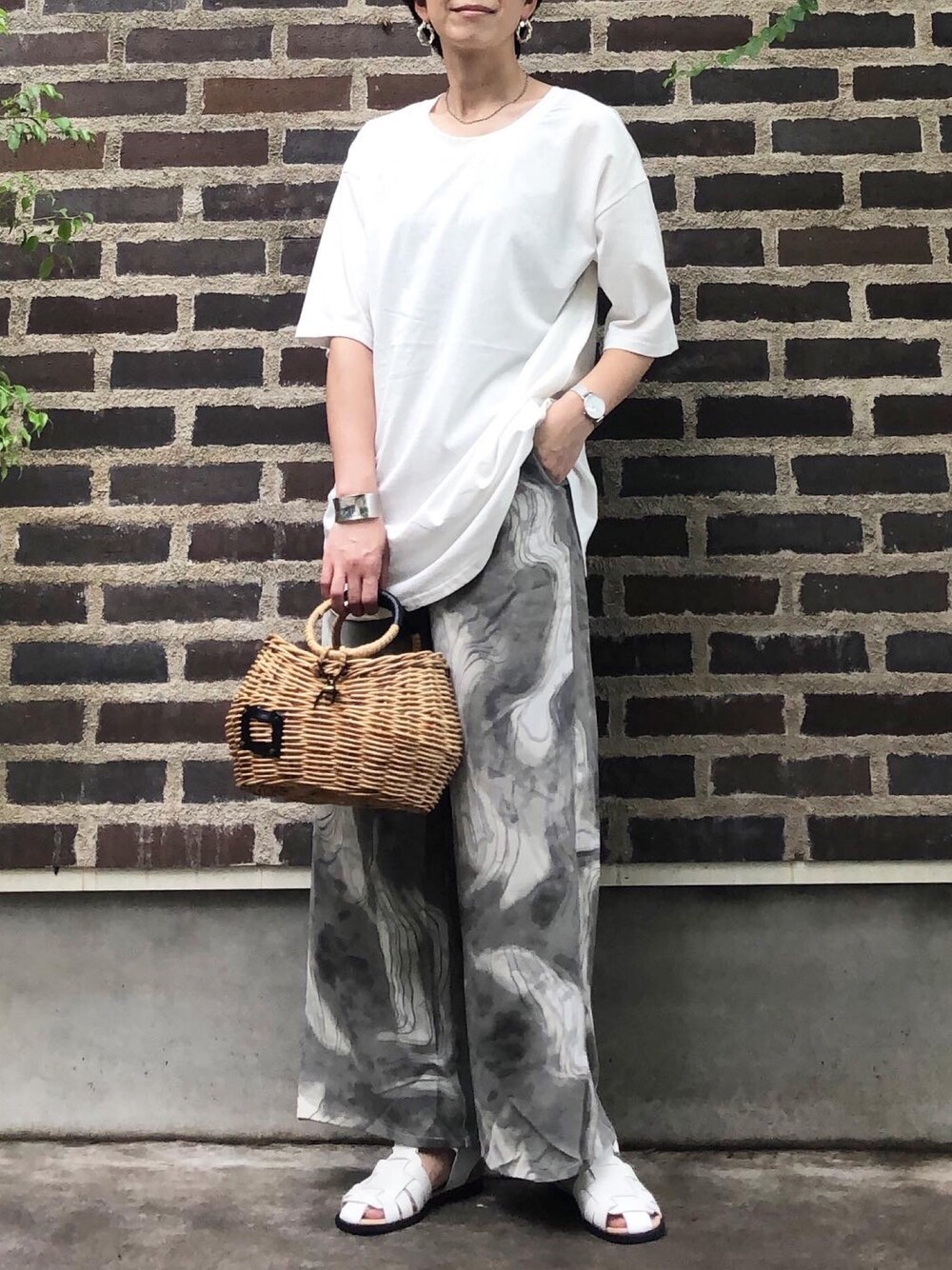 グレー系のその他パンツ、ホワイト系のサンダル、ホワイト系のTシャツ/カットソーを着用したレディースの夏コーディネートの1枚目の写真