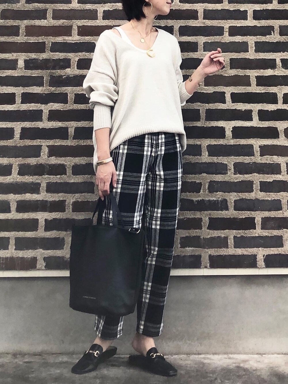 ベージュ系のニット/セーター、その他のパンツ、ブラック系のサンダルを着用したレディースの秋コーディネートの1枚目の写真
