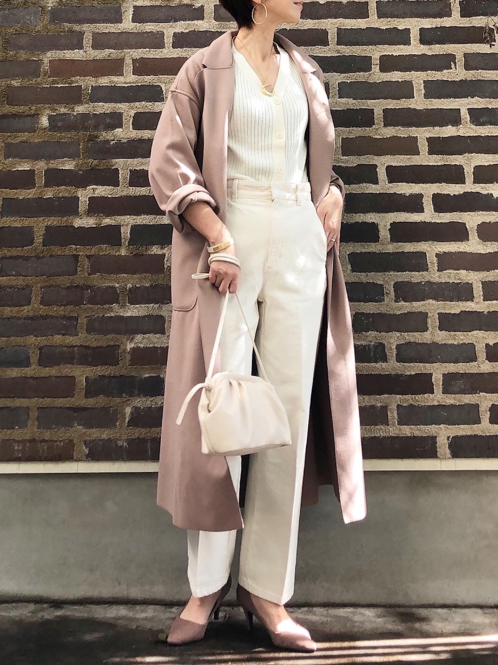 ブラウン系のチェスターコート、ホワイト系のデニムパンツ、ホワイト系のショルダーバッグを着用したレディースの秋コーディネートの1枚目の写真