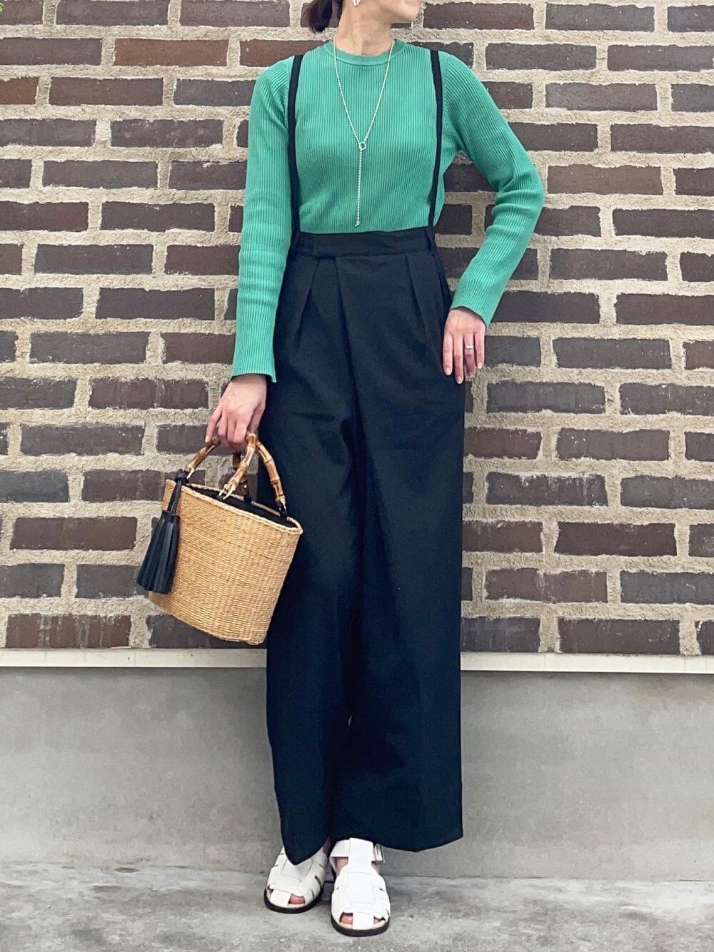 グリーン系のニット/セーター、ブラック系のその他パンツ、ホワイト系のサンダルを着用したレディースの春コーディネートの1枚目の写真