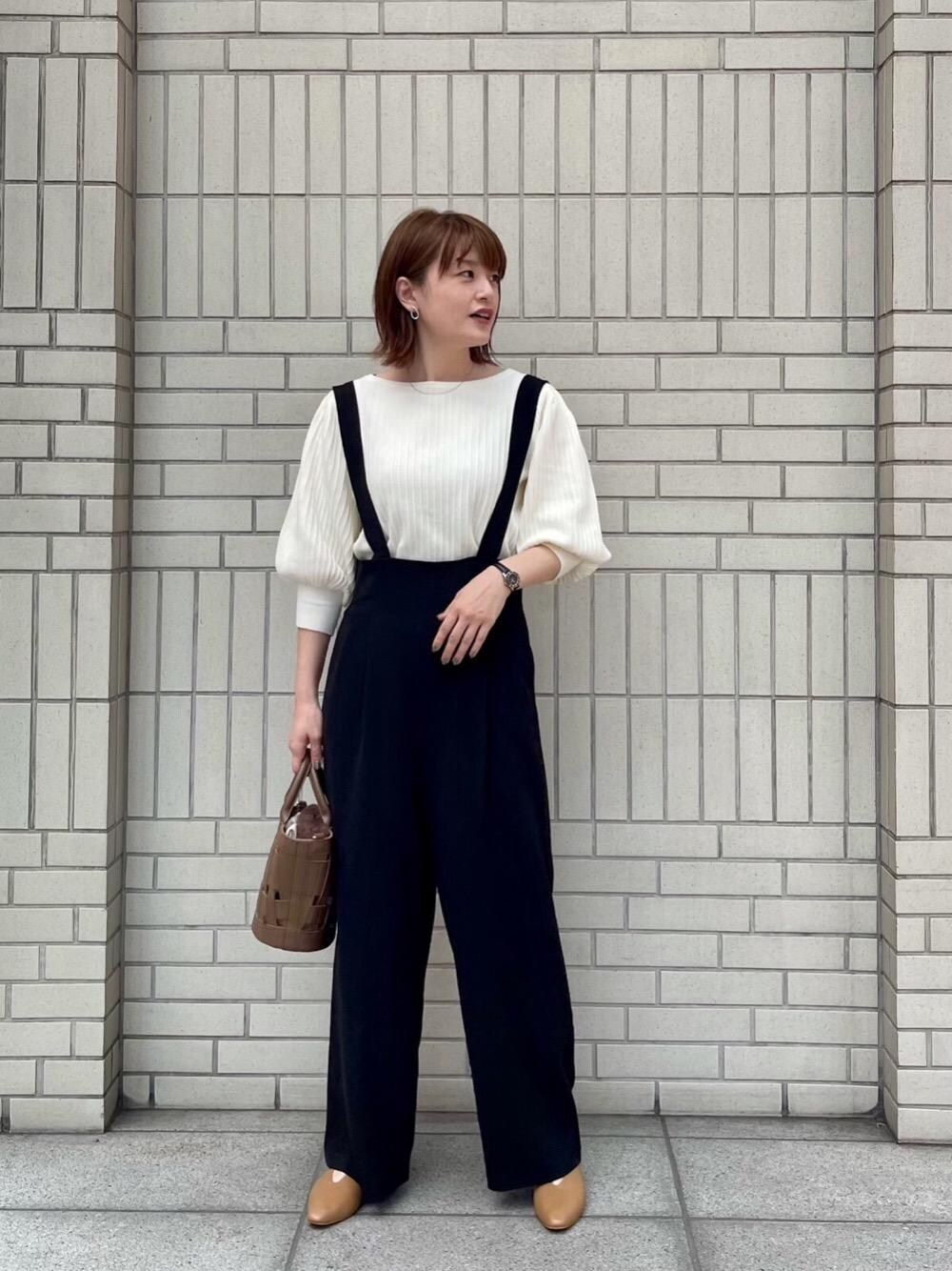 イエロー系のパンプス、ベージュ系のトートバッグを着用したレディースの夏コーディネートの1枚目の写真