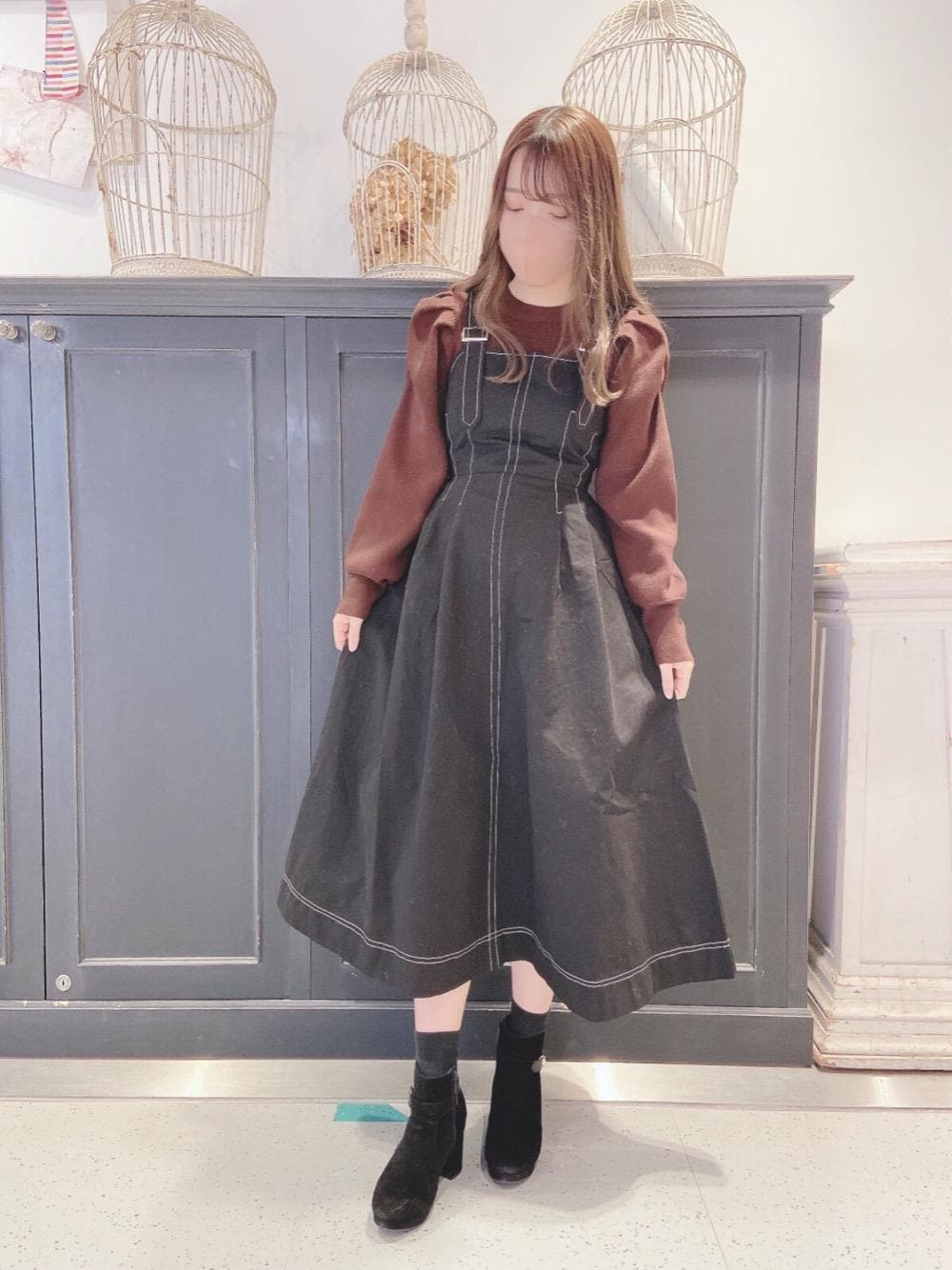 ブラック系のブーツ、ブラック系のワンピース、ブラウン系のニット/セーターを着用したレディースの冬コーディネートの1枚目の写真