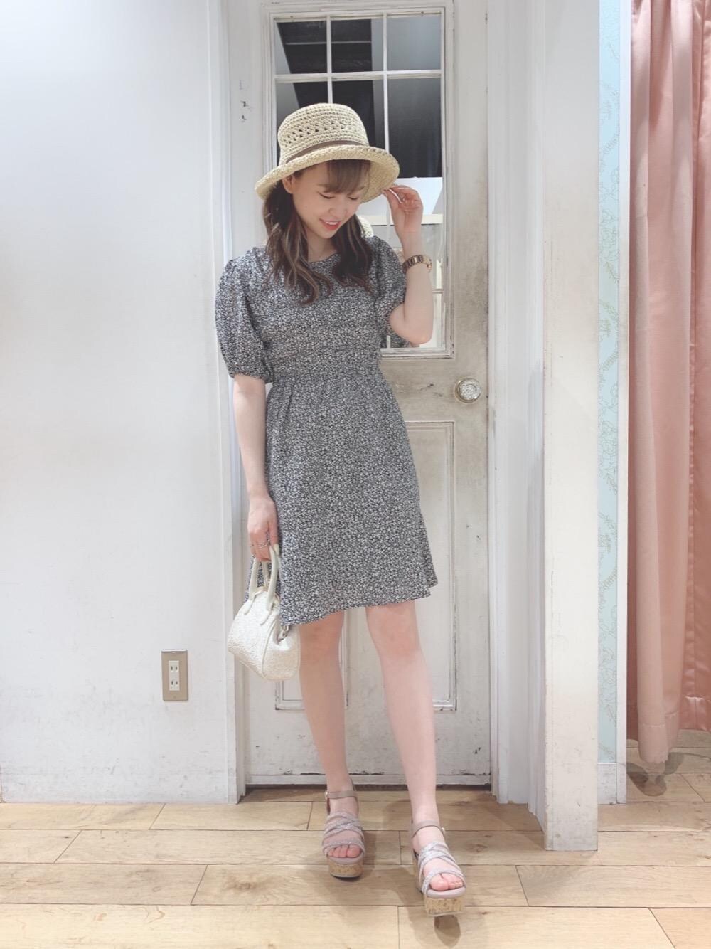 ベージュ系のサンダル、ホワイト系のショルダーバッグ、ブラック系のワンピースを着用したレディースの春コーディネートの1枚目の写真