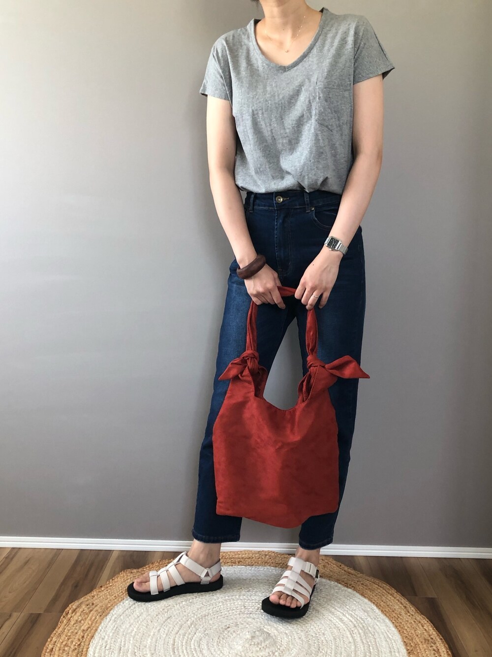 グレー系のTシャツ/カットソー、ブルー系のデニムパンツ、ブラウン系のトートバッグを着用したレディースの夏コーディネートの1枚目の写真