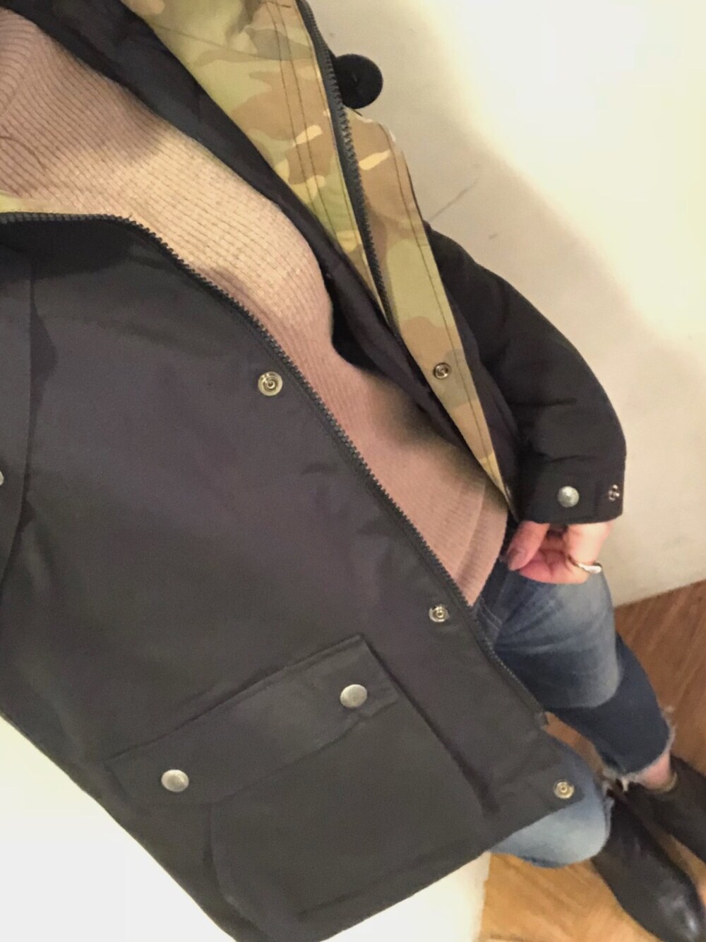 ブラック系のマウンテンパーカー、ベージュ系のニット/セーター、ブルー系のデニムパンツを着用したレディースの冬コーディネートの1枚目の写真