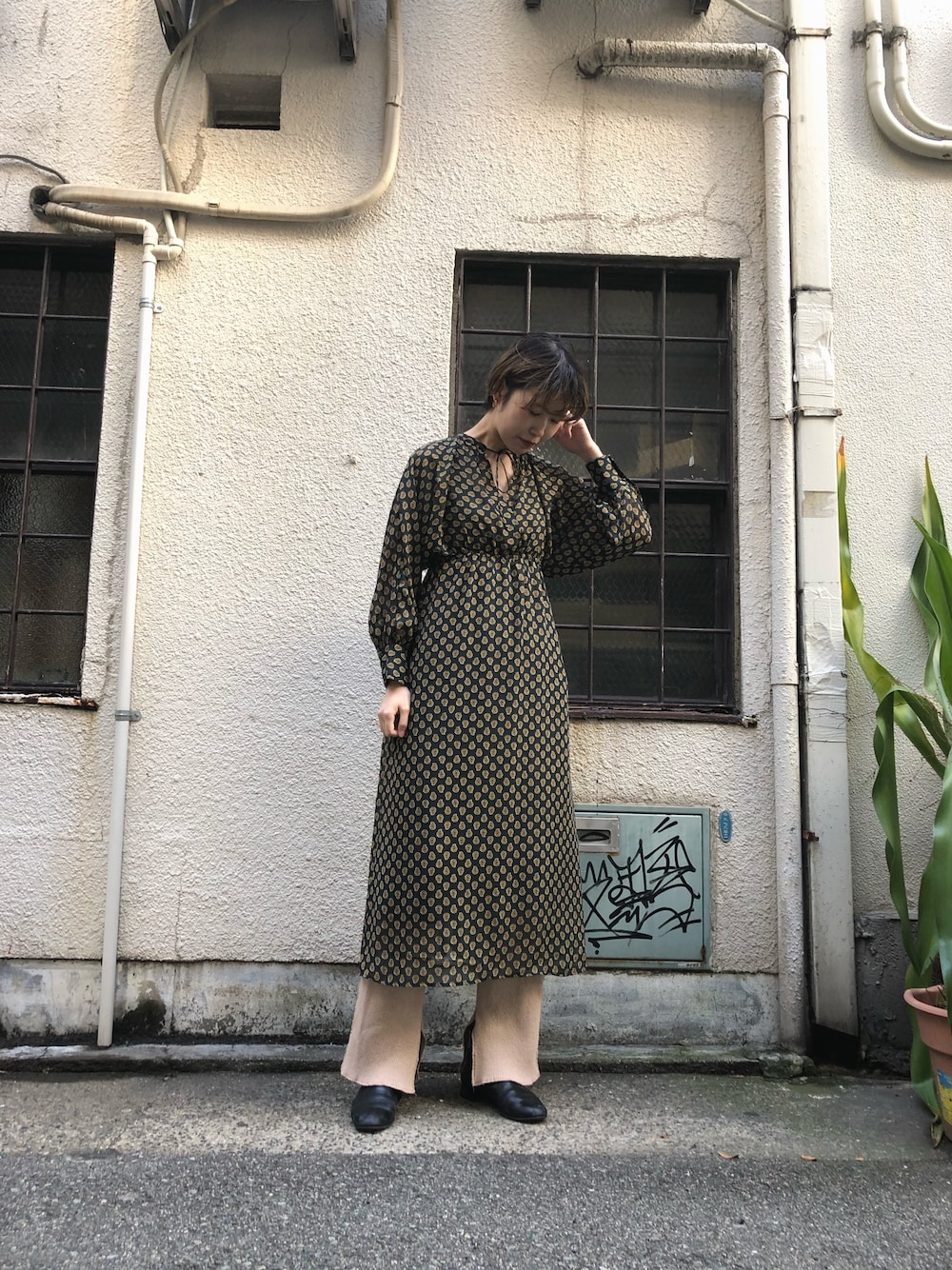 イエロー系のワンピースを着用したレディースの冬コーディネートの1枚目の写真