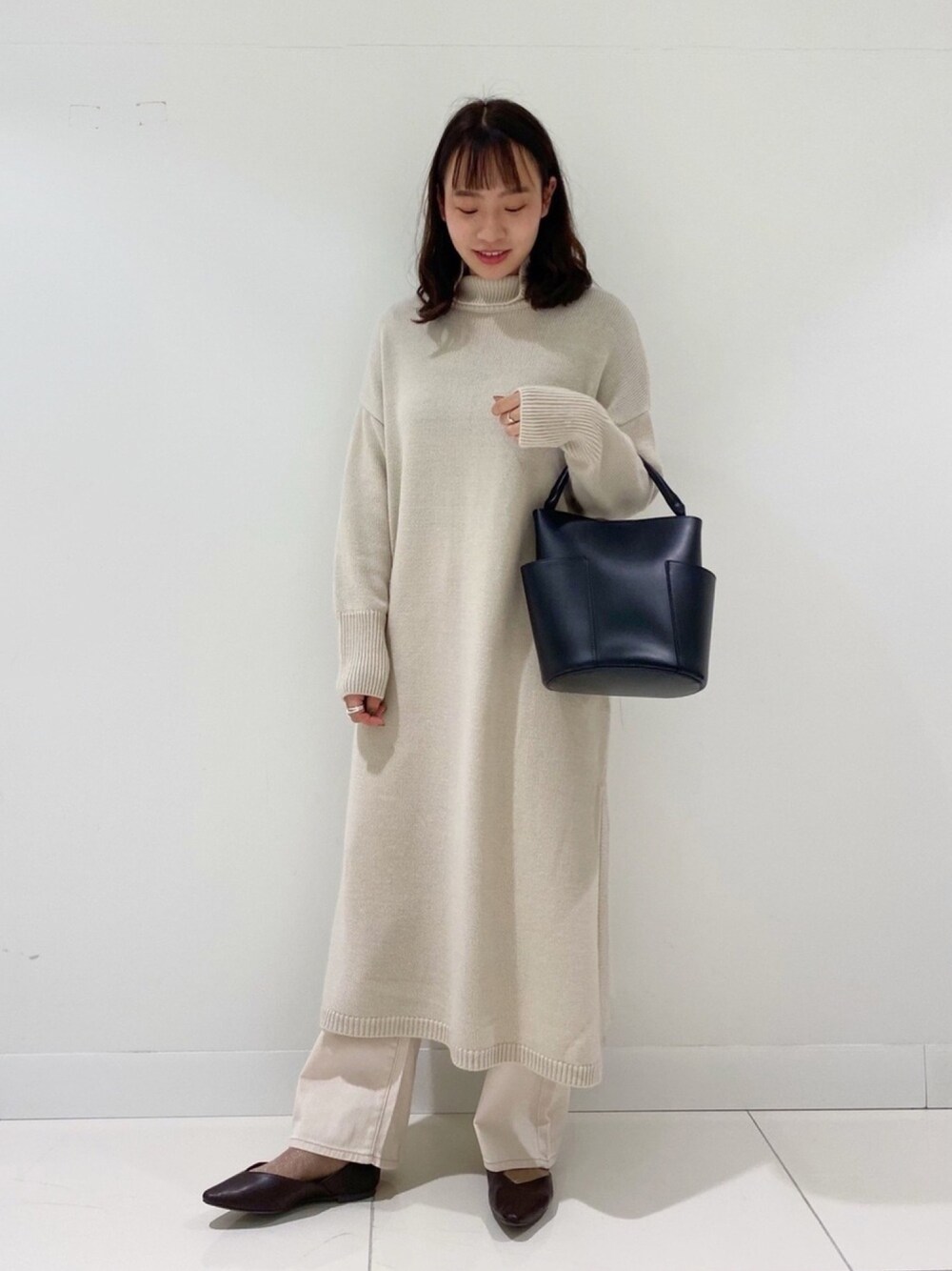 ホワイト系のワンピース、ホワイト系のデニムパンツ、ブラウン系のその他シューズを着用したレディースの冬コーディネートの1枚目の写真