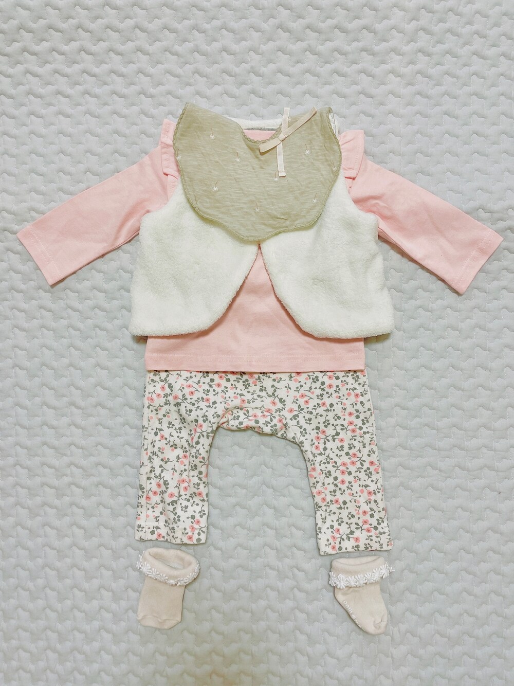 グリーン系のスタイ/よだれかけ、ピンク系のその他ベビーウェア、ホワイト系のその他ベビーウェアを着用したキッズの冬コーディネートの1枚目の写真