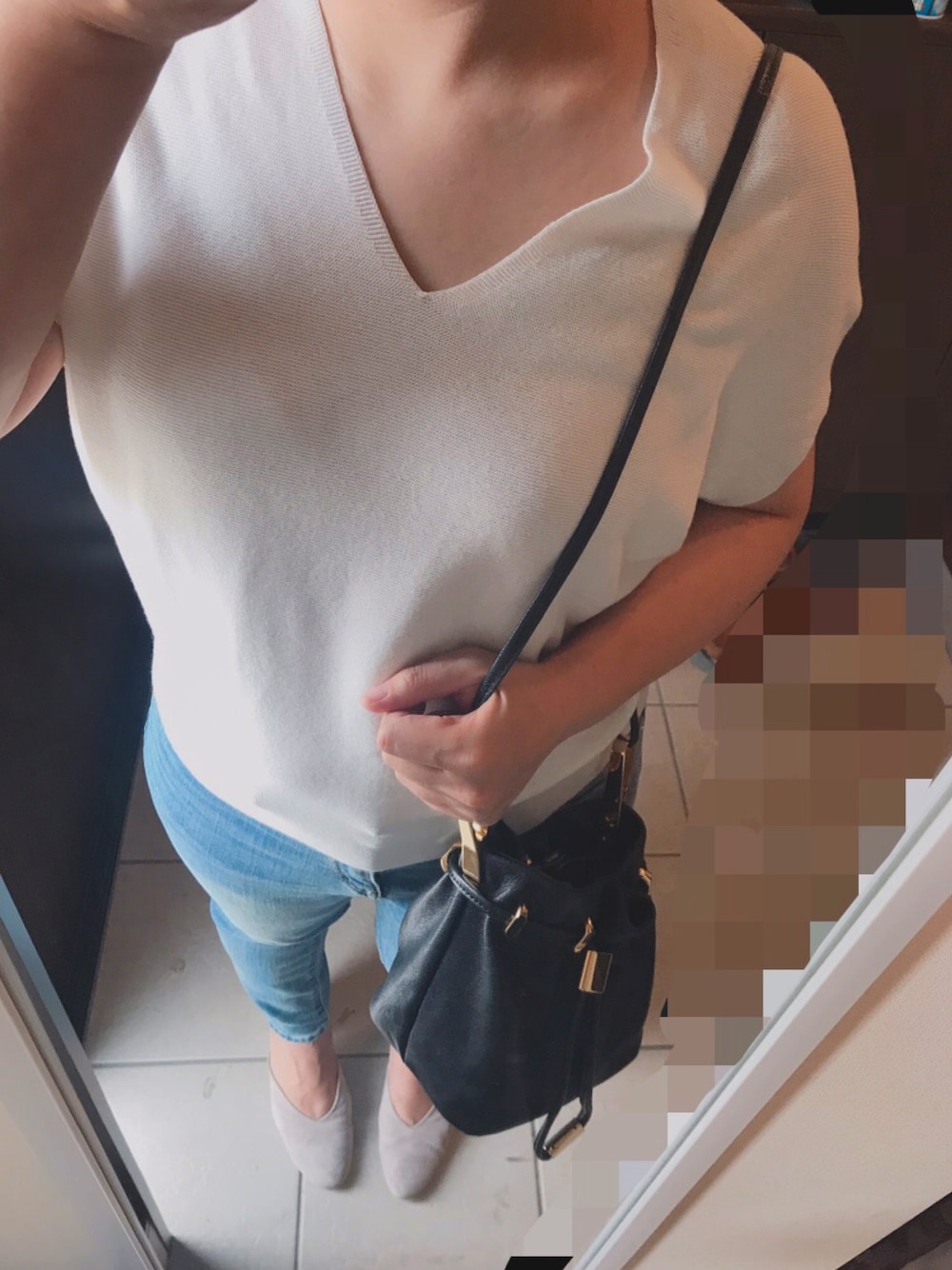 ホワイト系のニット/セーター、ブルー系のデニムパンツ、ブラック系のバッグを着用したレディースの夏コーディネートの1枚目の写真