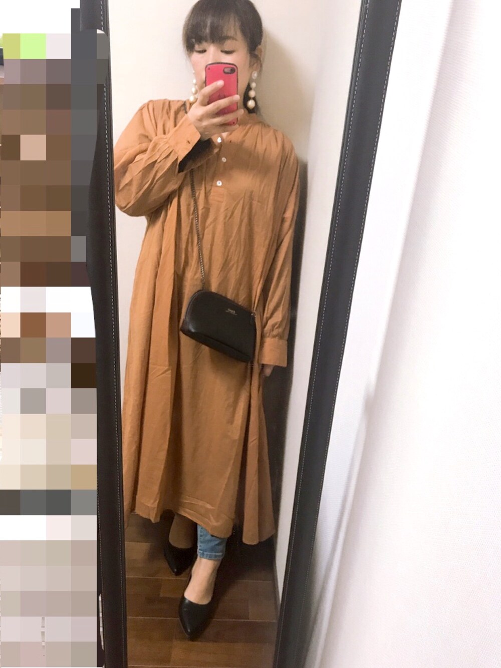 イエロー系のシャツワンピース、ブルー系のデニムパンツ、ブラック系のパンプスを着用したレディースの春コーディネートの1枚目の写真