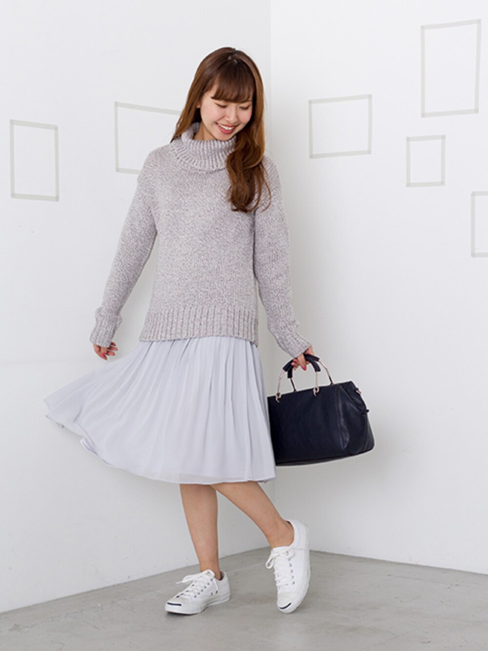 グレー系のニット/セーター、グレー系のスカートを着用したレディースの冬コーディネートの1枚目の写真