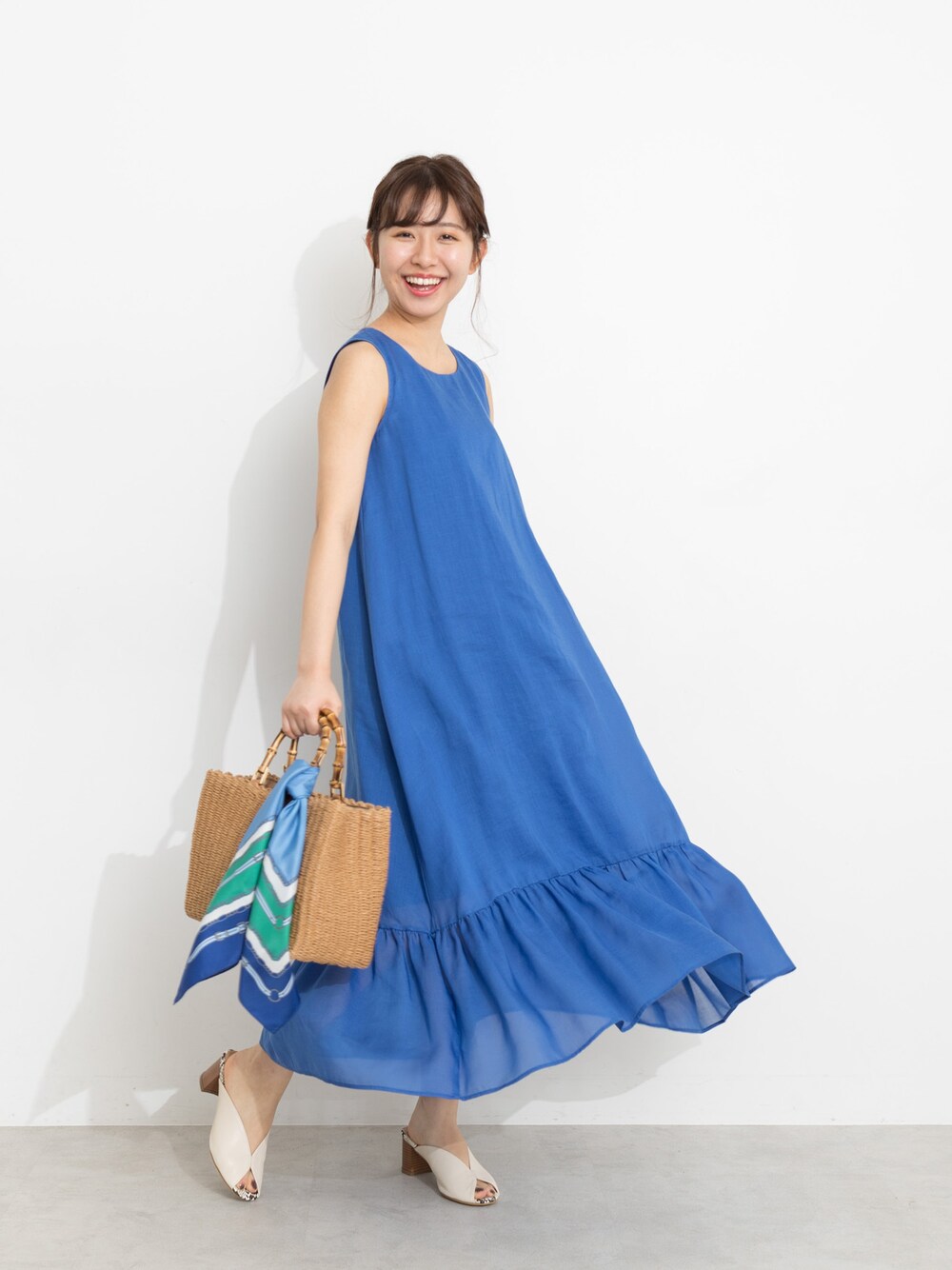 ブルー系のワンピース、イエロー系のハンドバッグ、ホワイト系のサンダルを着用したレディースの春コーディネートの1枚目の写真