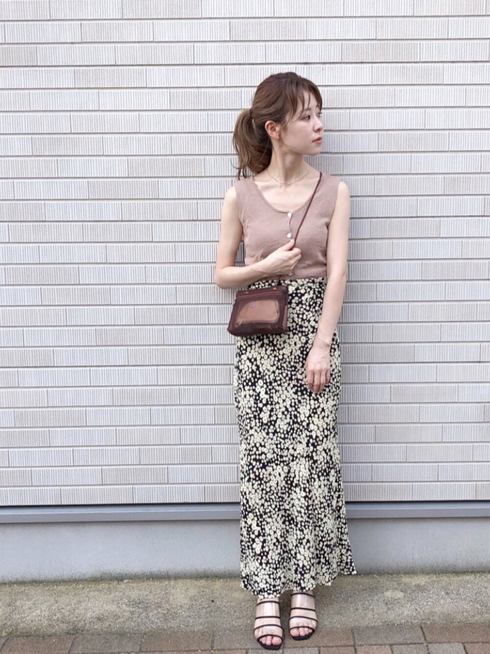 ピンク系のタンクトップ、ブラウン系のショルダーバッグ、ブラック系のスカートを着用したレディースの夏コーディネートの1枚目の写真