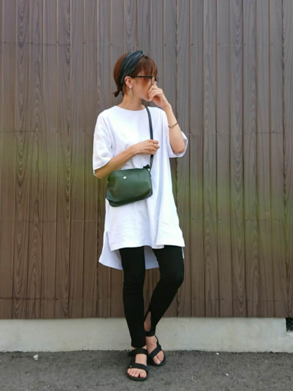 ブラック系のショルダーバッグ、ホワイト系のTシャツ/カットソー、ブラック系のサンダルを着用したレディースの夏コーディネートの1枚目の写真